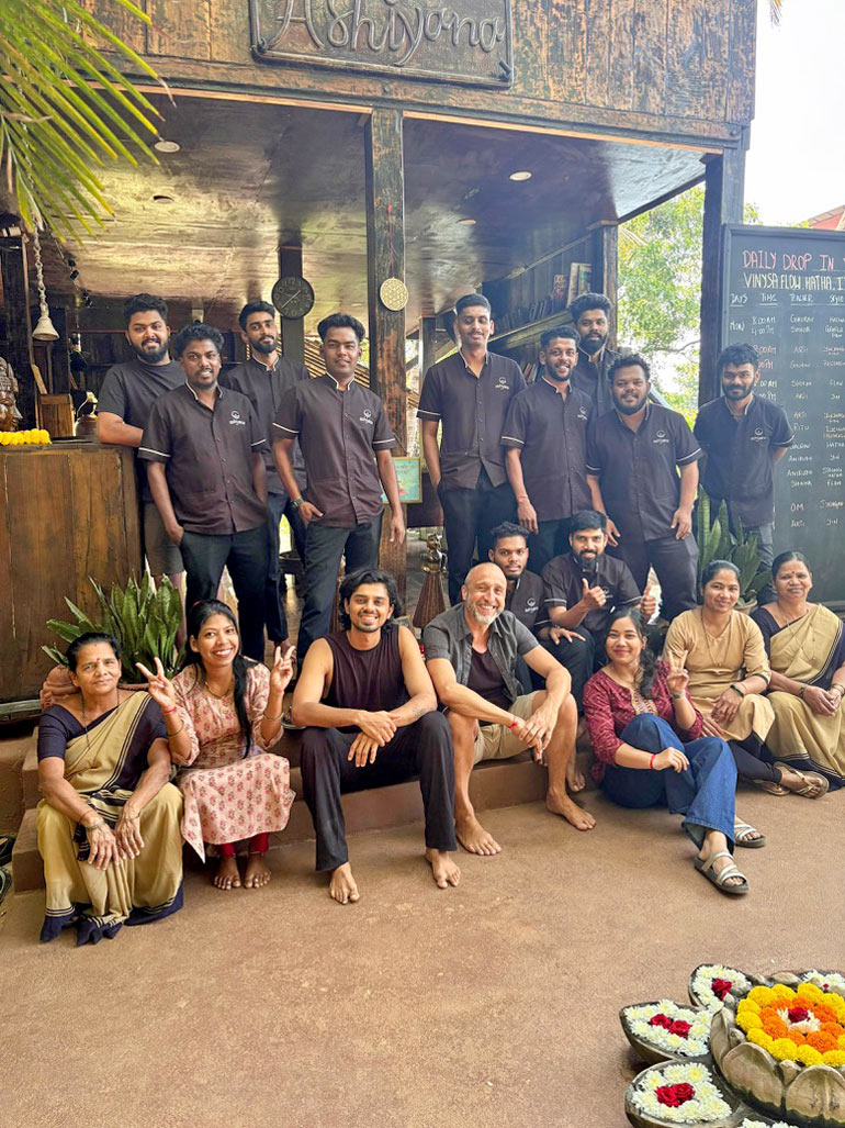 Team des Ashiyana Yoga Retreats in Goa posiert gemeinsam vor dem Eingang